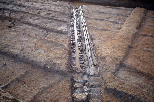 石組の水路と土管が水田の中に埋められています